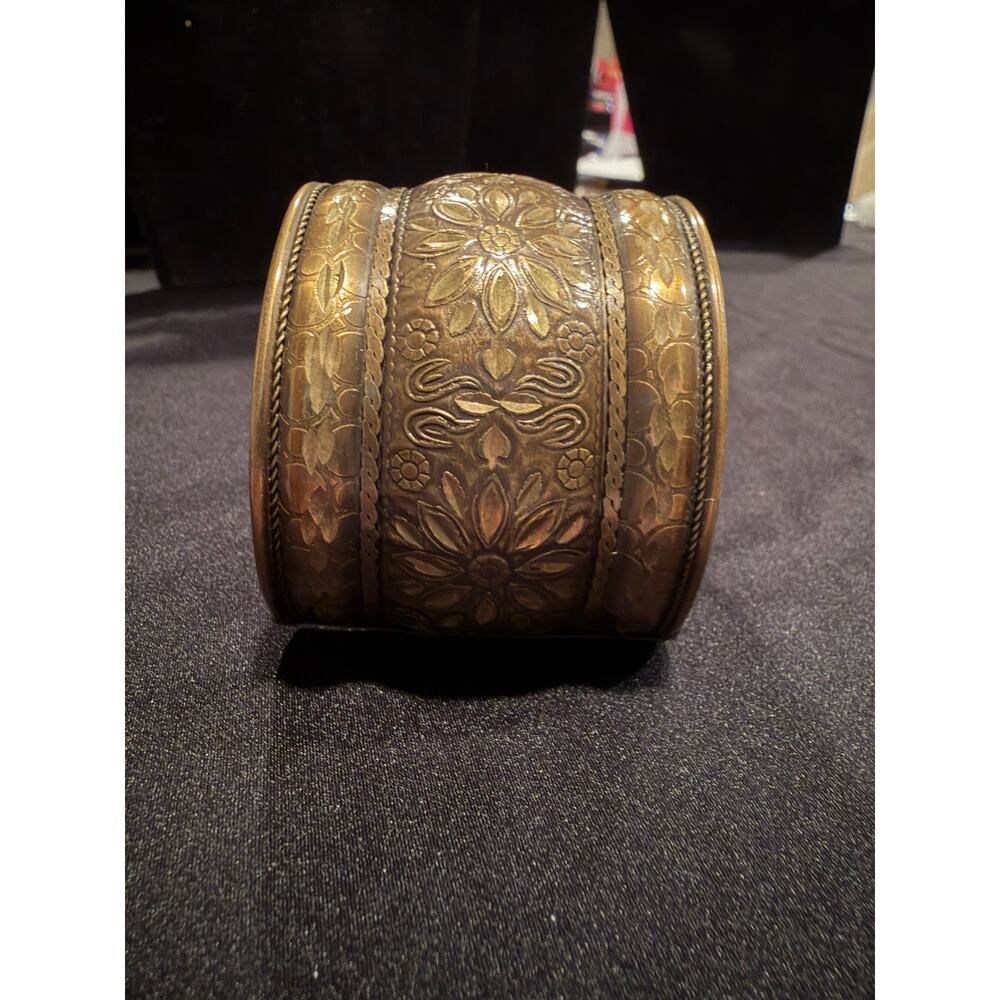 Vintage or antique brass cuff bracelet featuring an intricate floral design